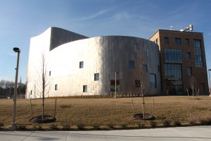 Exterior of the Performing Arts and Humanities Building. Semi-circular and made of silver panels.