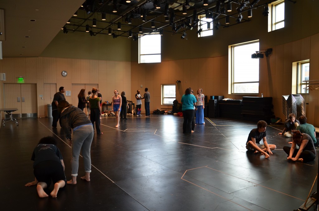 Inside of the Theatre Rehearsal Studio, filled with many students talking and stretching.