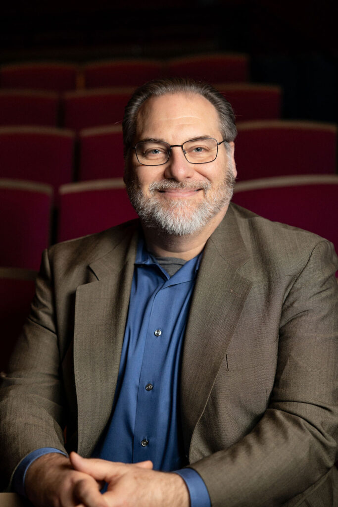 Professional Headshot of Adam Mendelson. He is white with a beard and glasses.