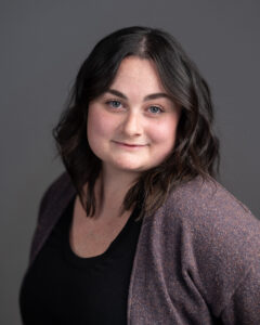 Headshot of Grace Shepperd. She is white, and has shoulder length dark brown hair.